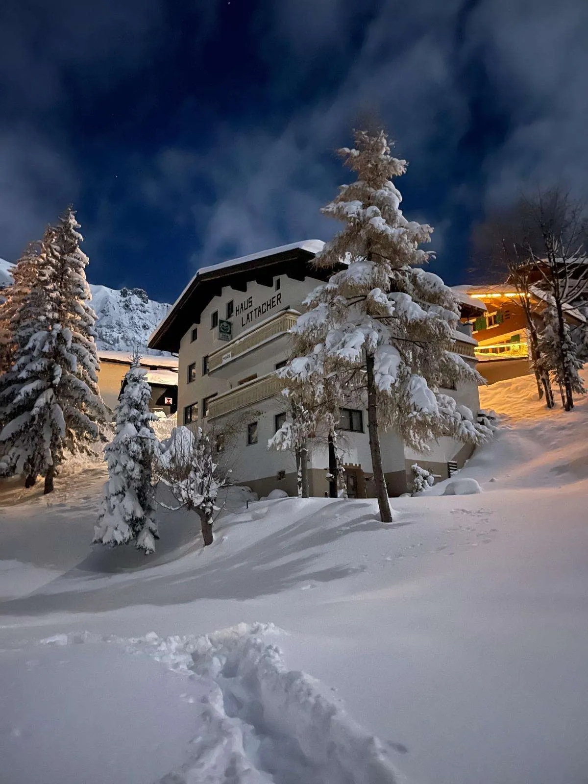 Het Arlberg Motel op een winteravond, met diepe sneeuw ervoor