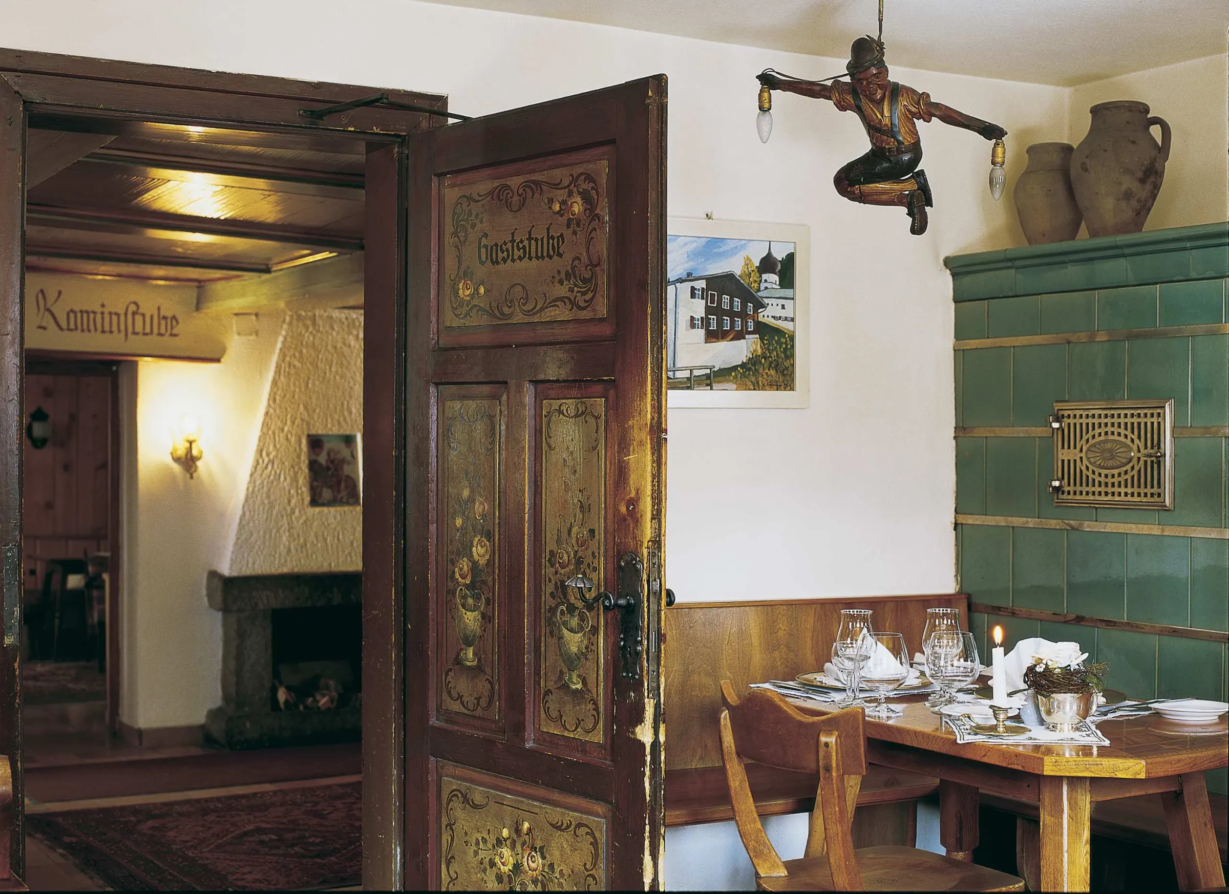Old parlour with a painted door and a green tiled stove