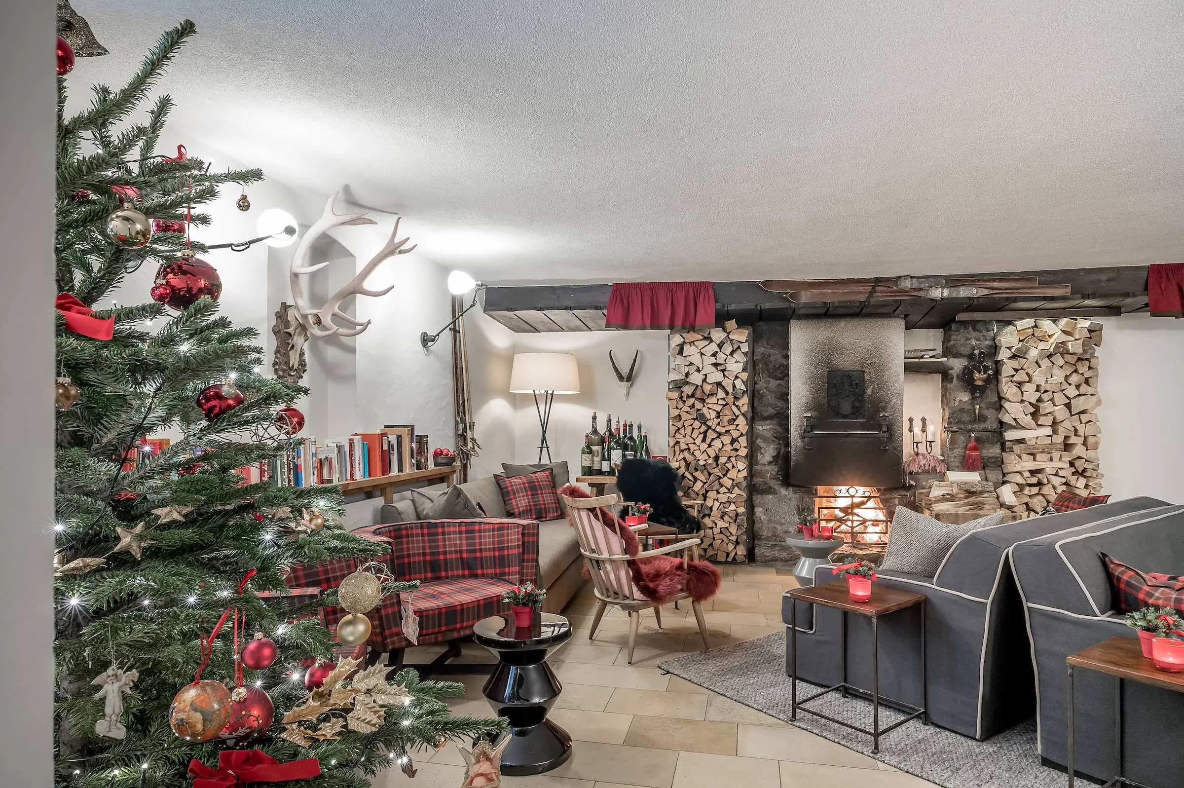 The fireside lounge with a fire, sofas and stacked logs