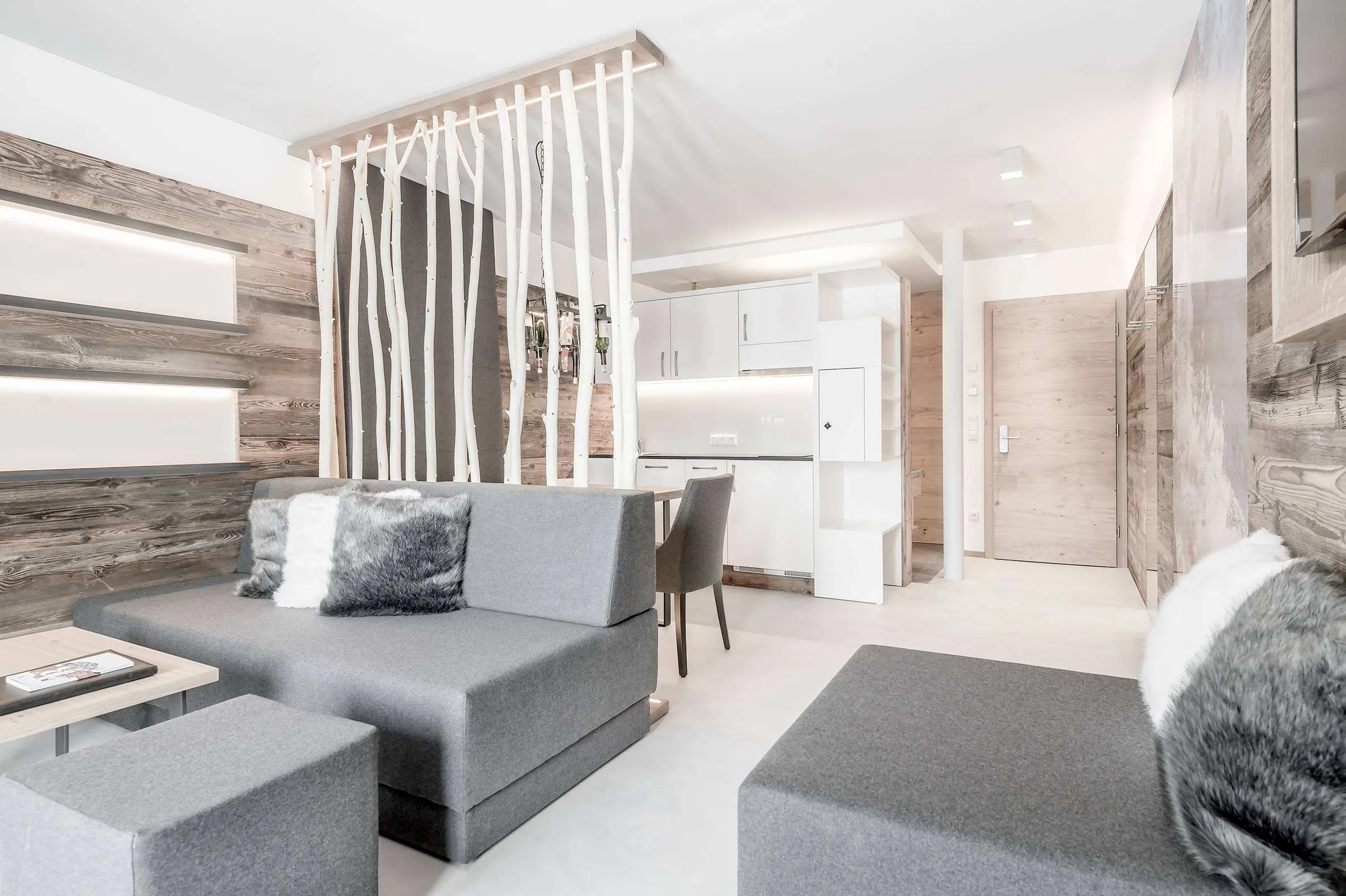 Living area of a suite with birch trunks and a freeride painting