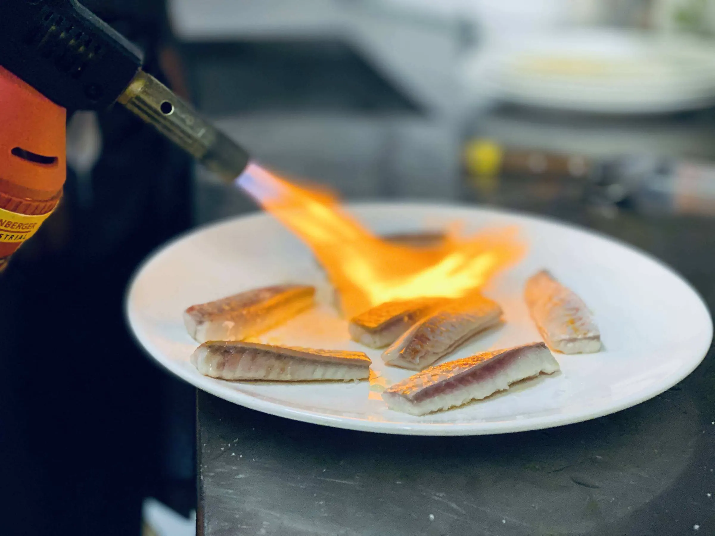 Vis wordt op het bord geflambeerd