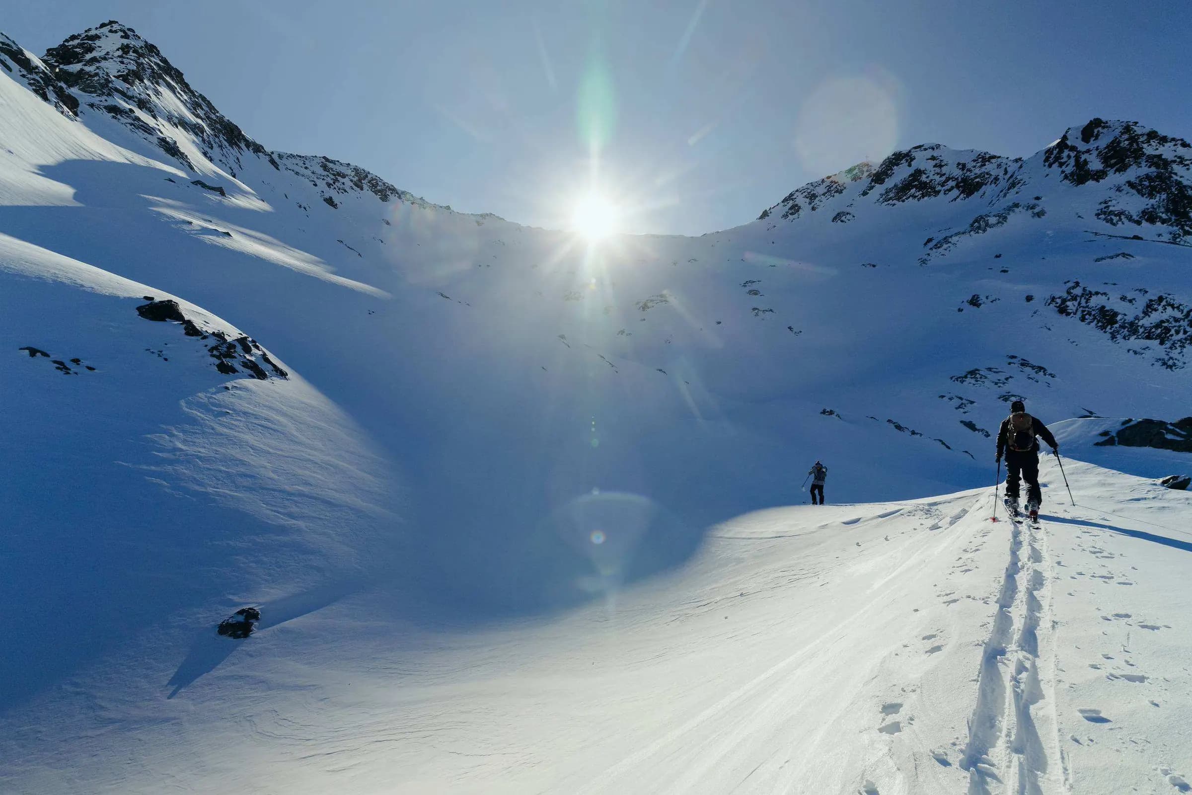 Toerskiër in tegenlicht, de zon als ster
