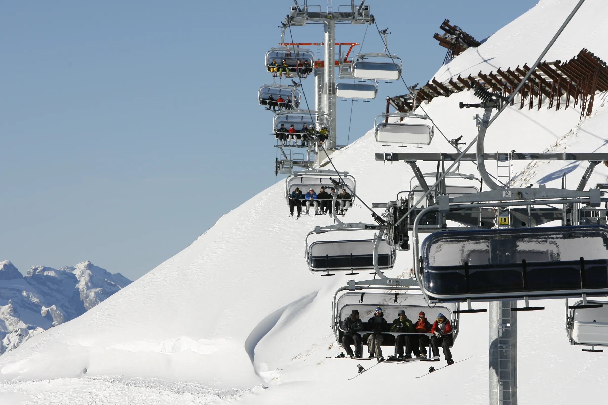 Stoeltjeslift met skiërs boven besneeuwde hellingen aan de Arlberg