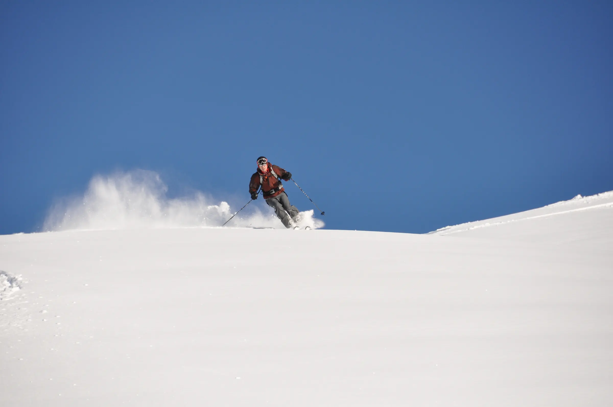 Skiër trekt een spoor door verse poedersneeuw