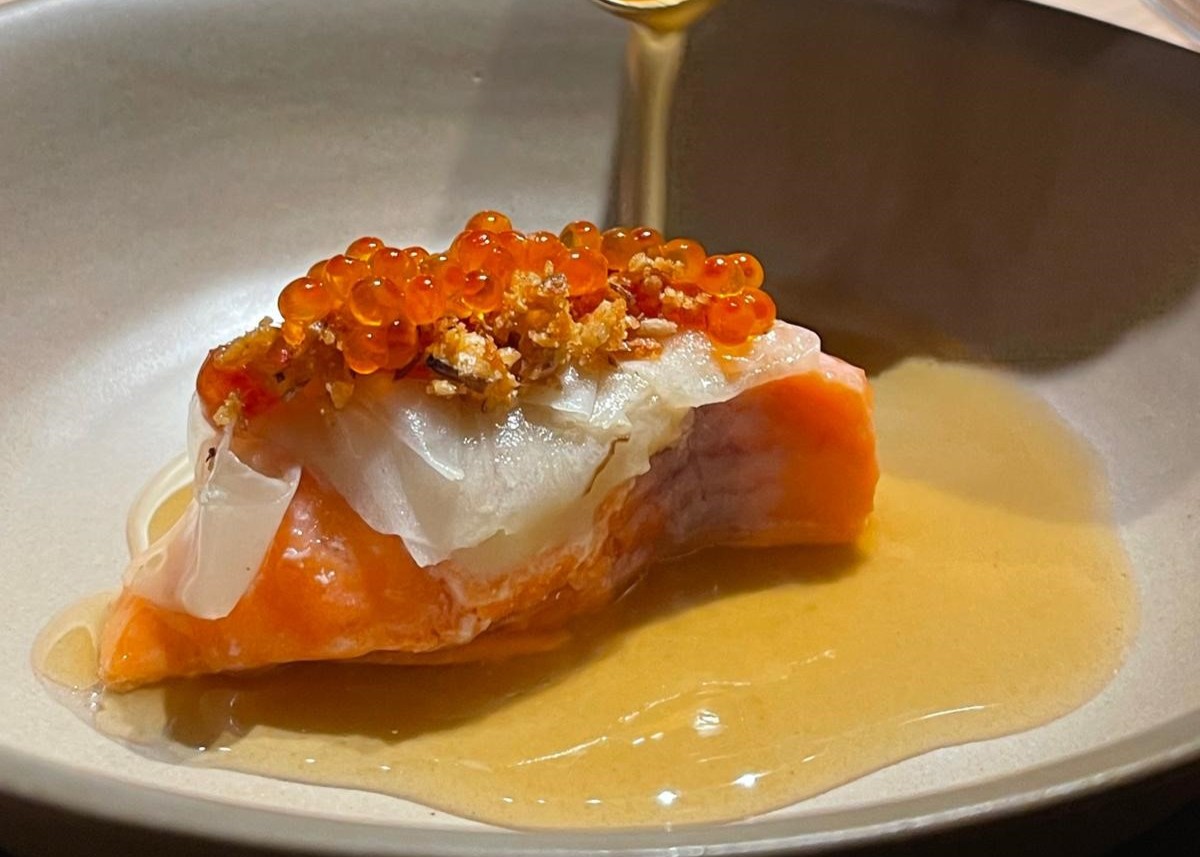 Close-up of a salmon dish with roe, pickled radish and sauce being spooned over at the Chef’s Table at Ski-Hotel Mondschein, Stuben am Arlberg