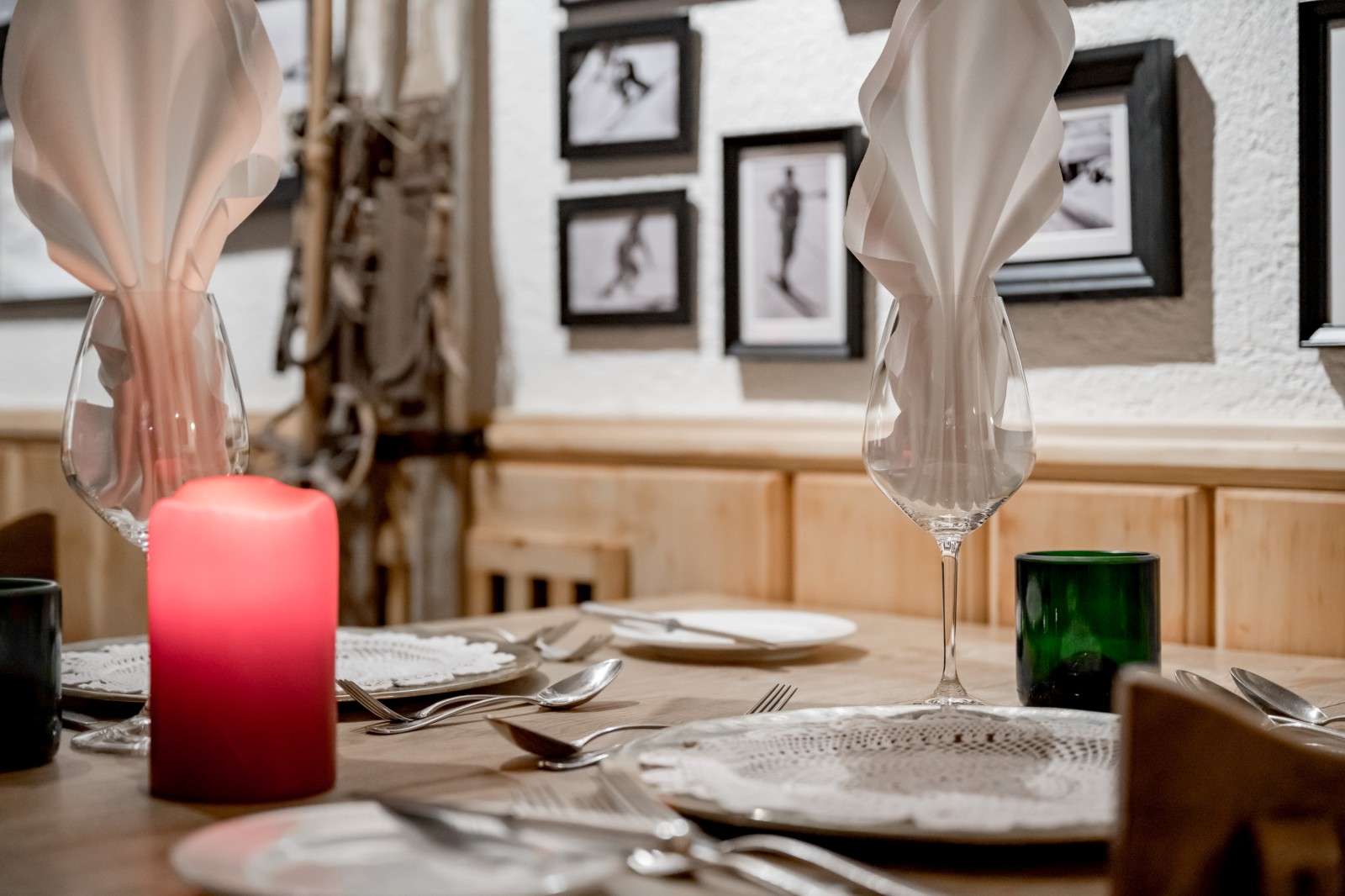 Close-up of a lovingly set wooden table with candlelight and silverware in the historic Alte Gaststube of Ski-Hotel Mondschein in Stuben am Arlberg