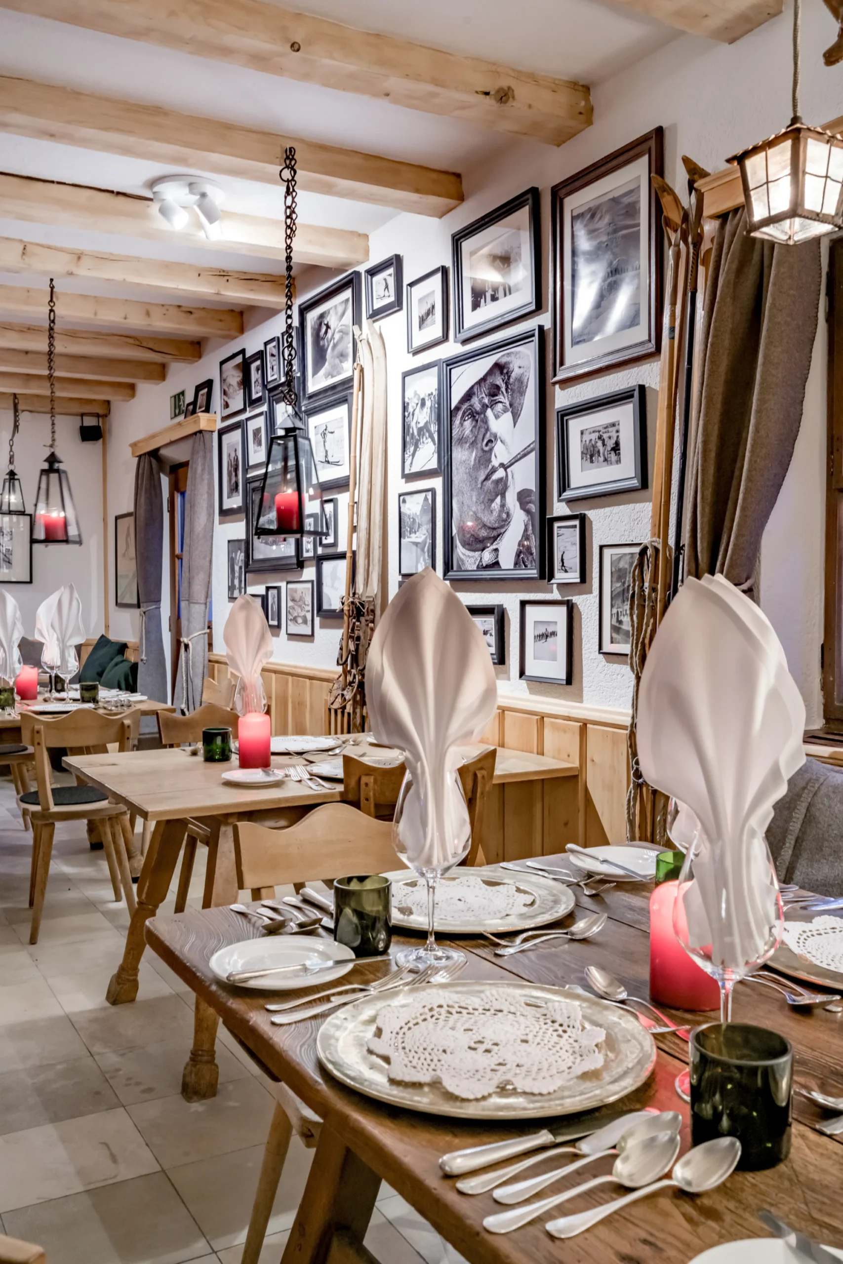 Cozy dining room with rustic wooden tables, traditional ski decor, and vintage black-and-white photos in Mondschein’s Alte Gaststube at Ski-Hotel Mondschein in Stuben am Arlberg