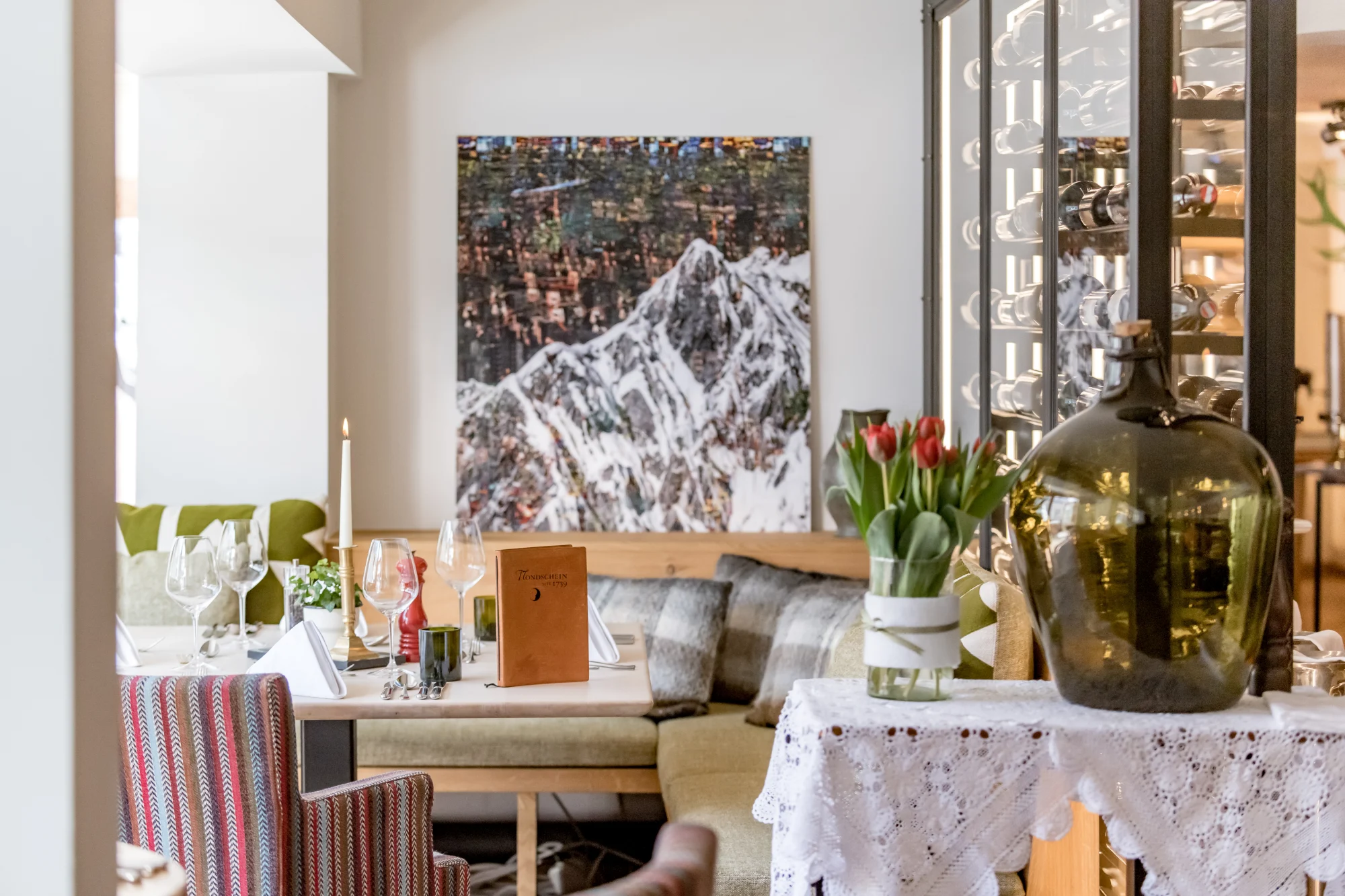 Intimate and elegantly set table with tulips and mountain artwork at Panorama Restaurant, Ski-Hotel Mondschein, Stuben am Arlberg
