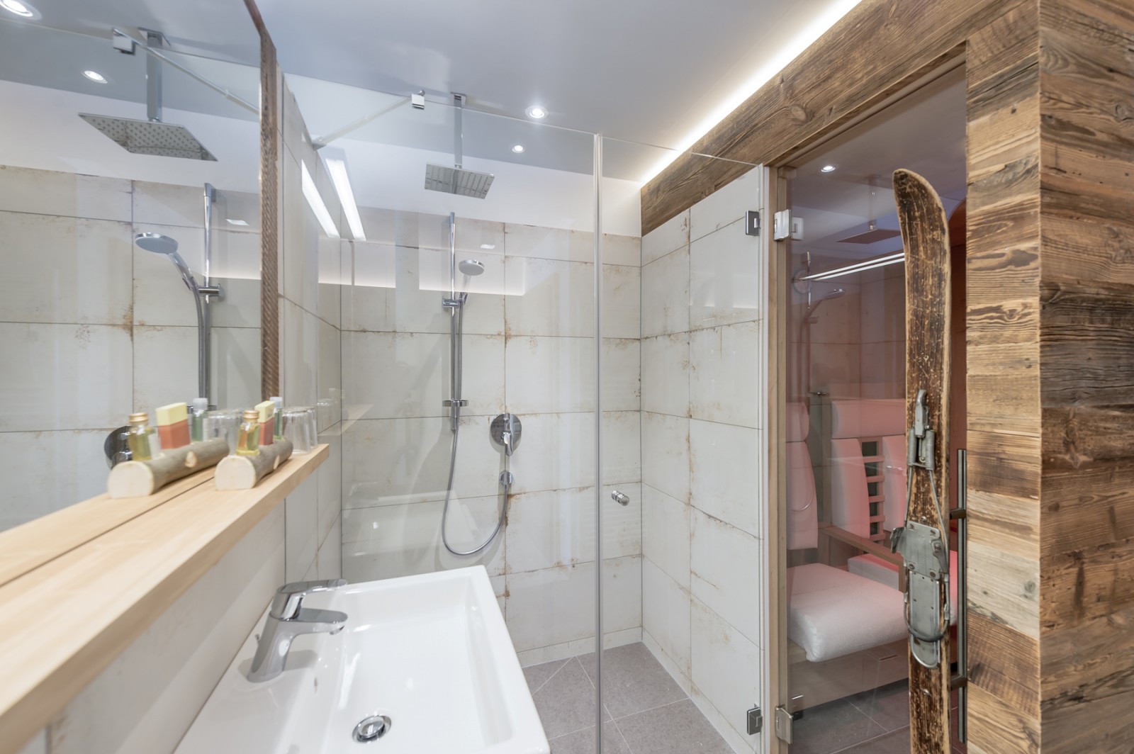 Modern bathroom with walk-in rain shower and private infrared cabin in the Private SPA Suite Premium at Chalet Mondschein, Stuben am Arlberg – alpine wellness luxury with natural materials and designer lighting