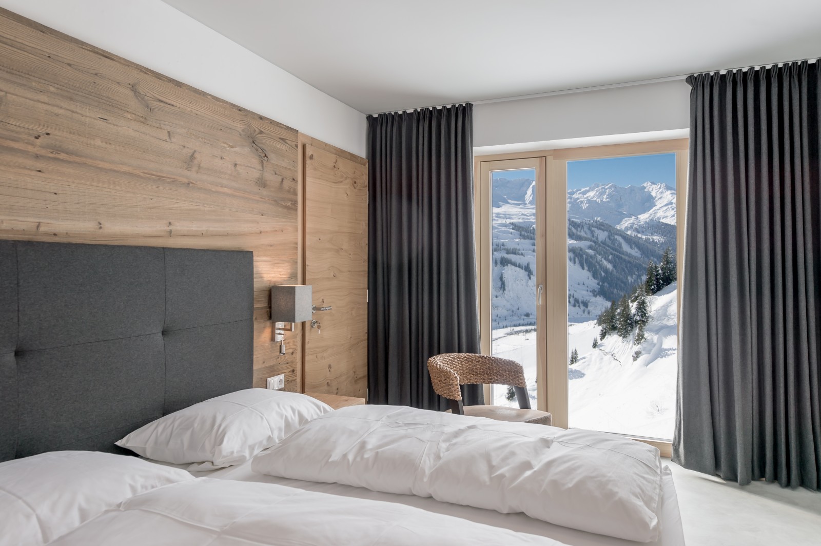 Comfortable box spring bed with a panoramic window overlooking the snow-covered mountains in the Private Family Room at Chalet Mondschein, Stuben am Arlberg