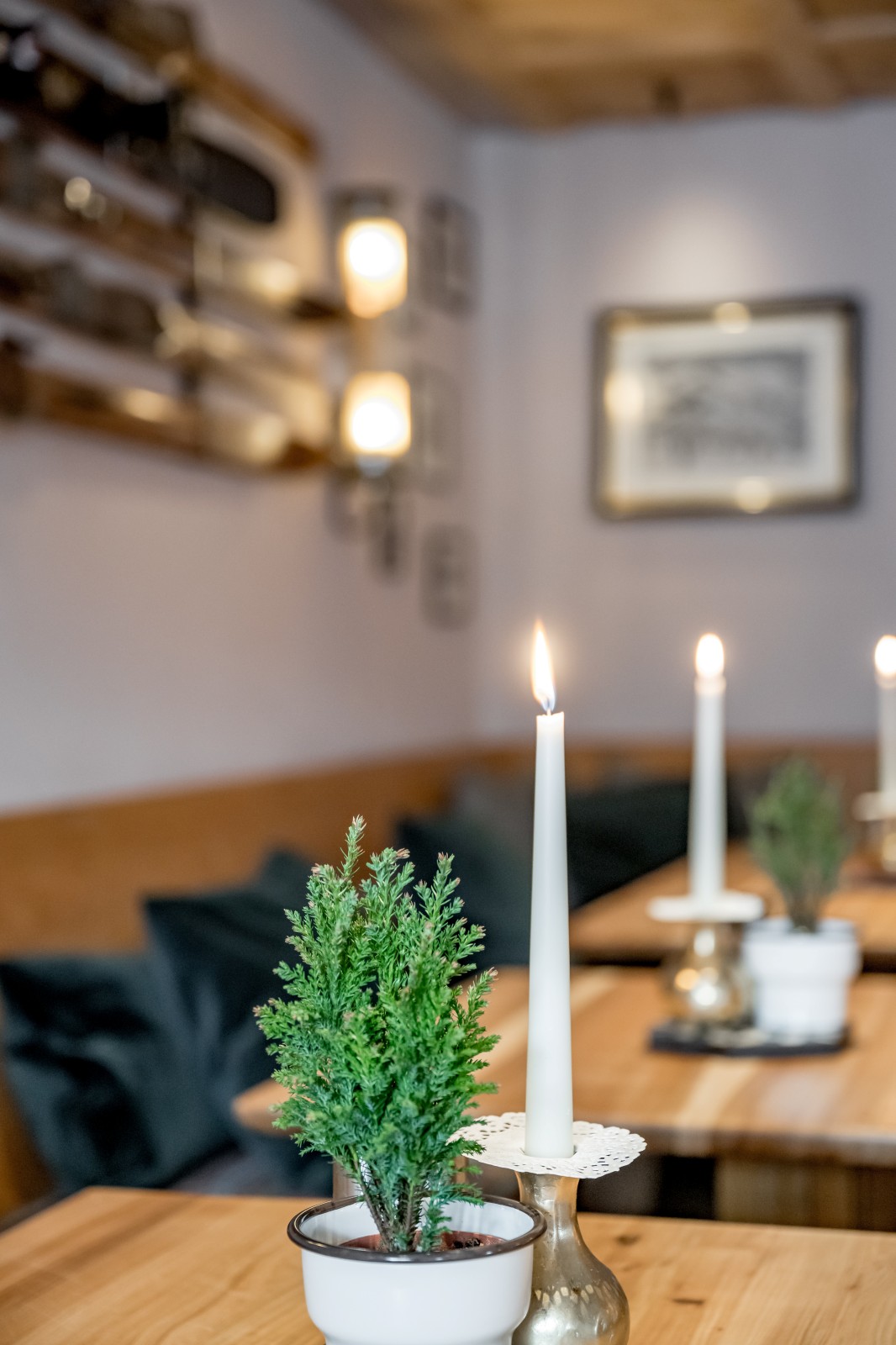 Bright corner with wooden benches, vintage ski decor, framed alpine photos, and candles in the Bilderzimmer next to the Fireplace Lounge at Ski-Hotel Mondschein