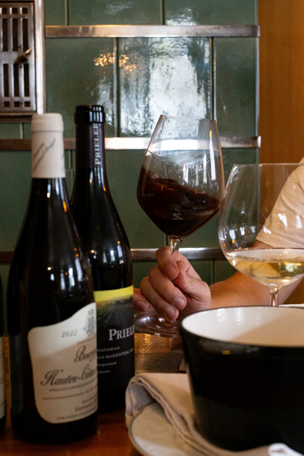 Fondue pot and glasses of Austrian wine on a table at Ski-Hotel Mondschein, Stuben am Arlberg – cozy gourmet experience with traditional Alpine flair