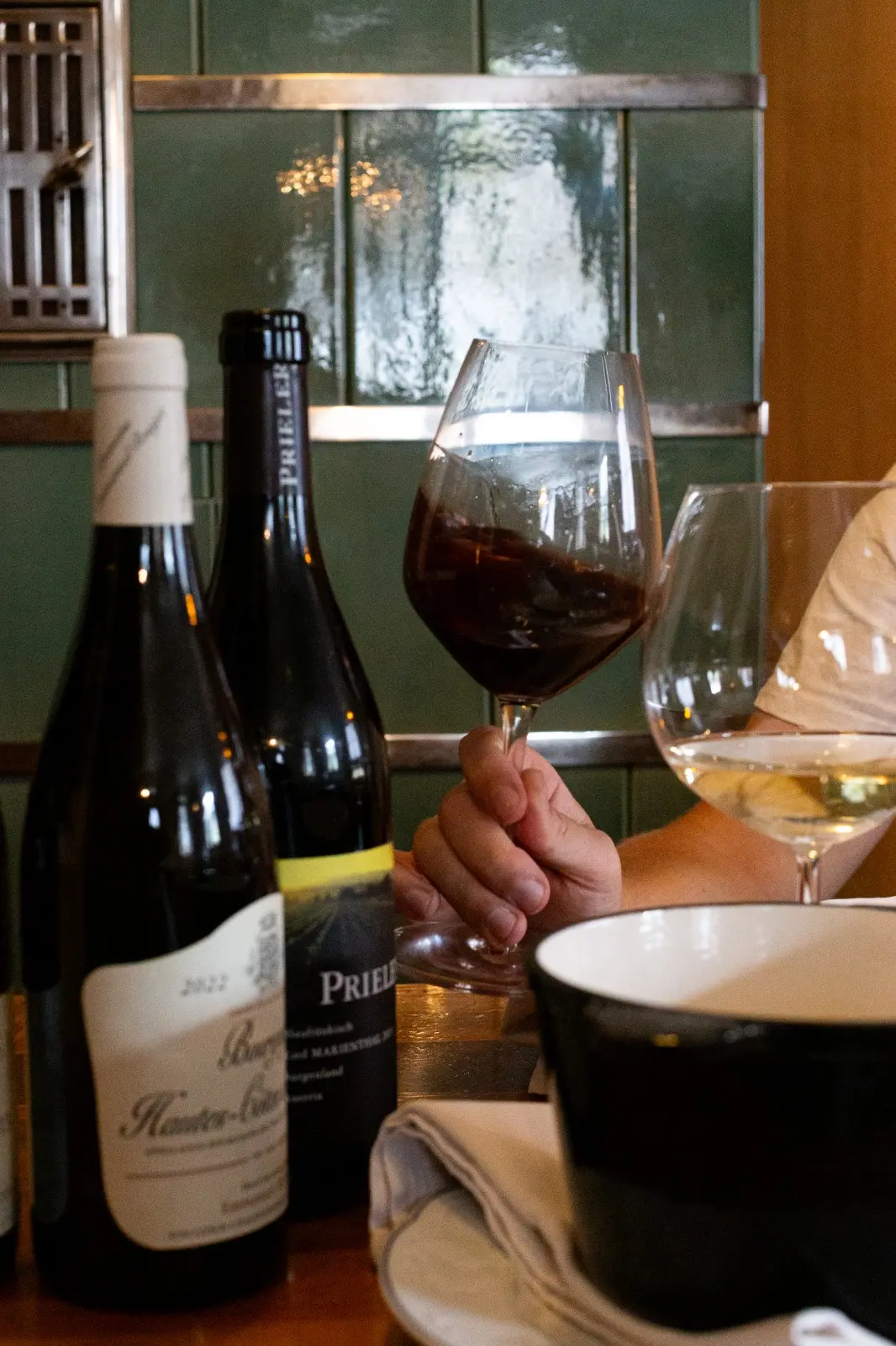 Fondue pot and glasses of Austrian wine on a table at Ski-Hotel Mondschein, Stuben am Arlberg – cozy gourmet experience with traditional Alpine flair