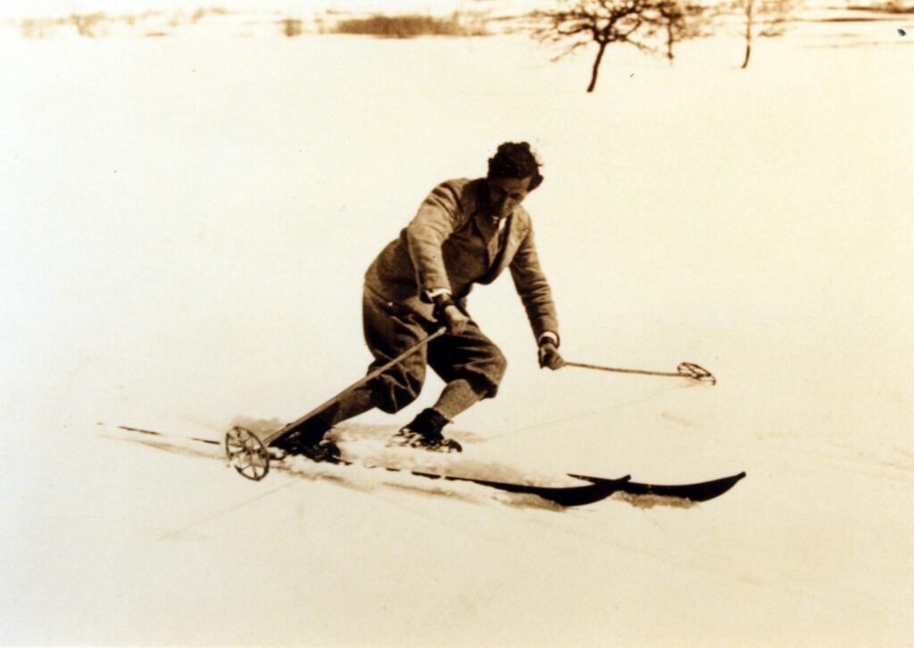 Historic photo of ski legend Hannes Schneider performing a classic alpine turn on a snowy slope in Japan, wearing traditional attire
Subtitle: The Arlberg technique goes global – Hannes Schneider's legacy in Japan
