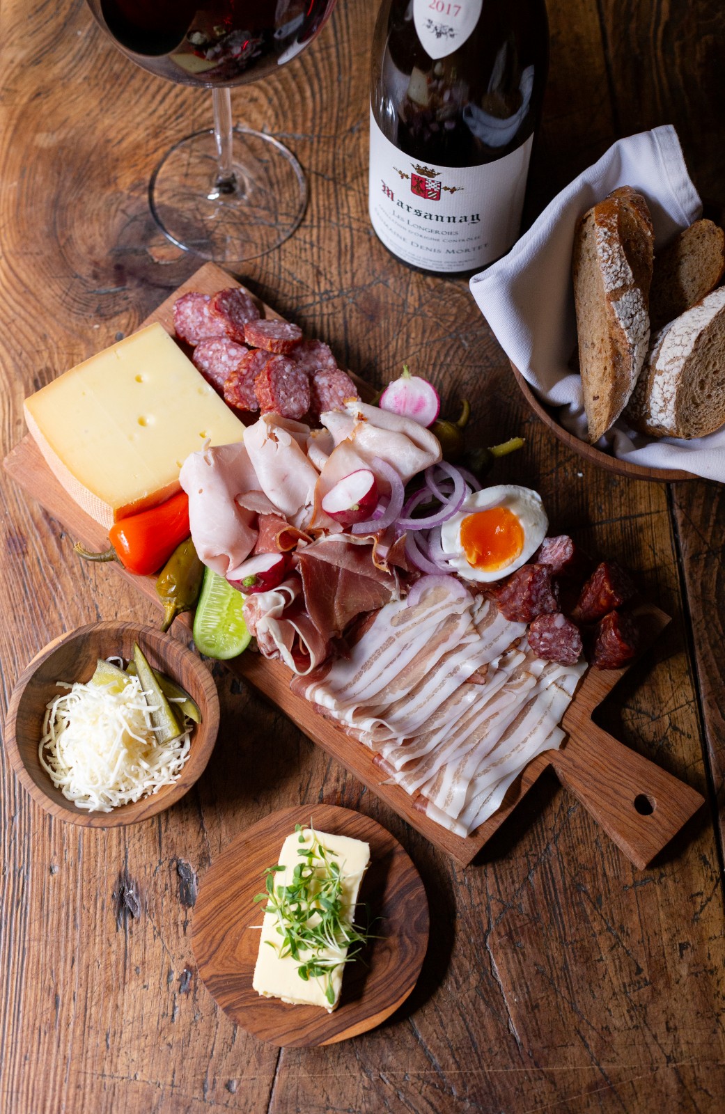 Rustic Austrian cold cuts and cheese platter with bread, butter, pickles and red wine served in the Alte Gaststube at Ski-Hotel Mondschein in Stuben am Arlberg