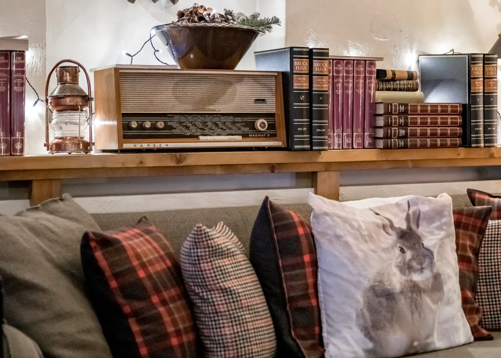Cozy reading nook with pinecone decorations, antique books, and a moon sculpture in the Fireplace Lounge at Ski-Hotel Mondschein, Stuben am Arlberg