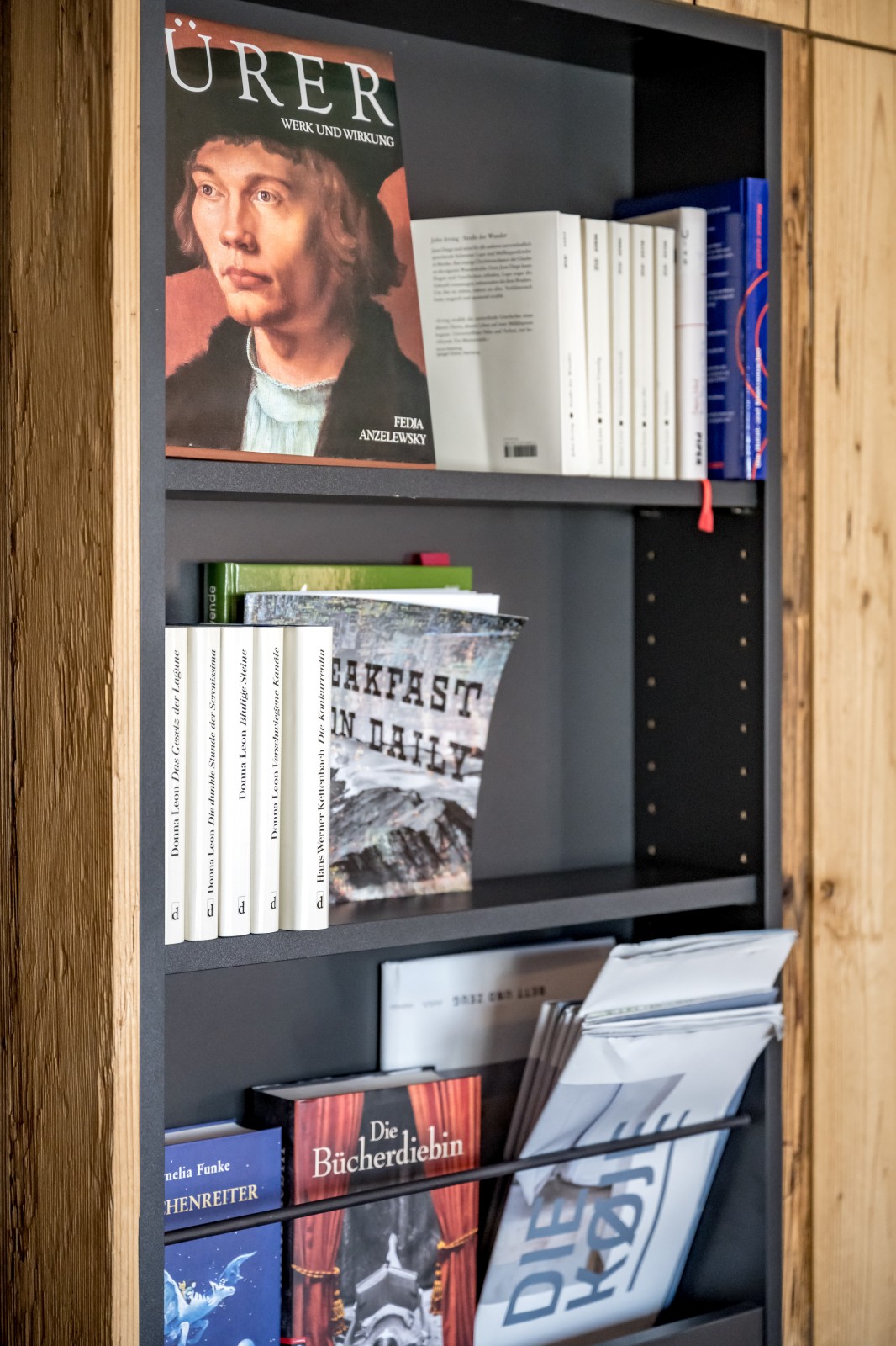 Close-up of a designer bookshelf with art books and novels inside the Private SPA Suite Exclusive at Chalet Mondschein in Stuben am Arlberg