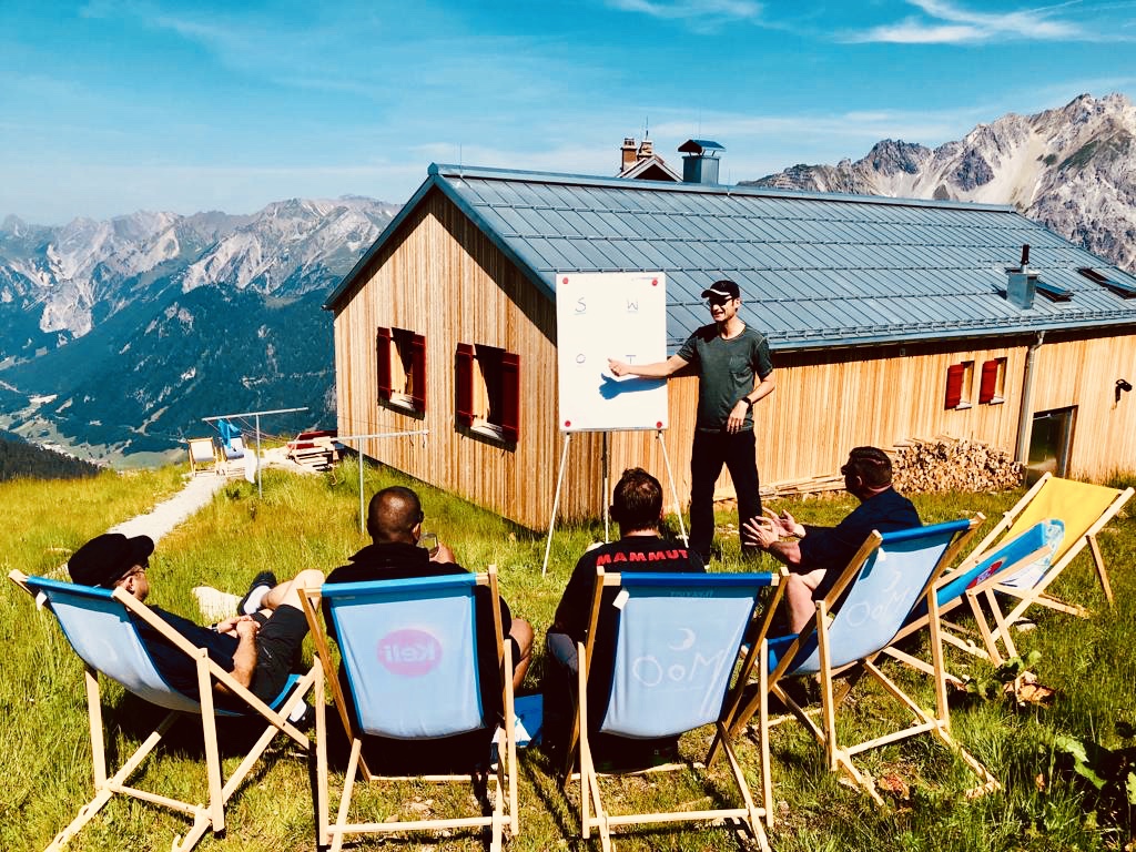 Outdoor seminar in deck chairs with panoramic mountain views in front of Kaltenberghütte in the Austrian Alps
